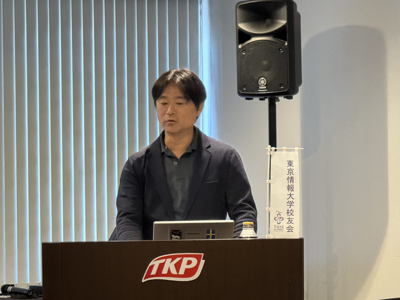 演台に立つ野澤和雅会長